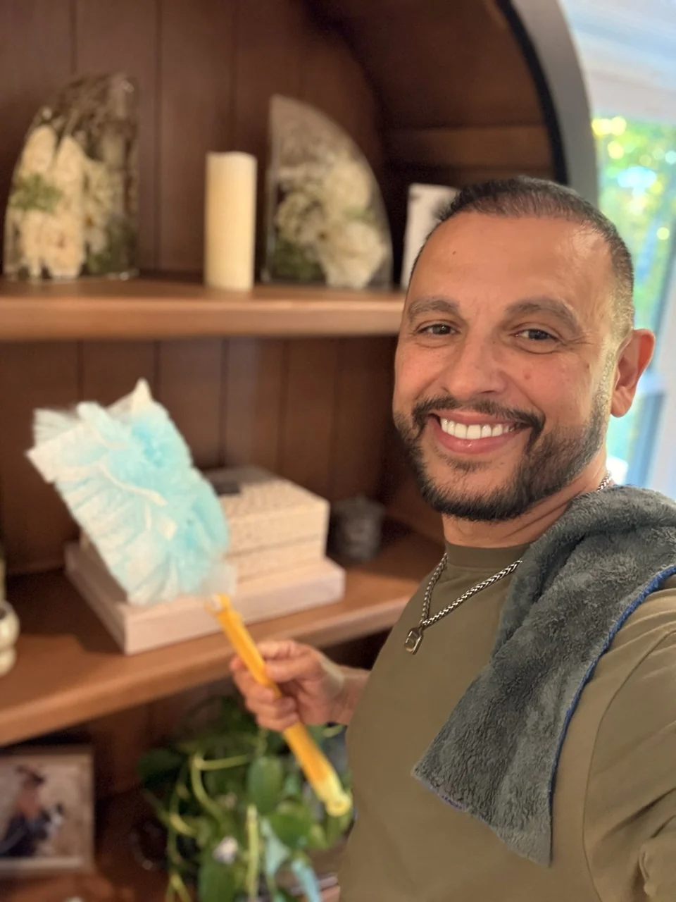 Rondi smiling while dusting a shelf